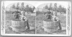 SA1639 - Photo shows Mead and Wilson getting a drink from a pump and large barrel. Ads for other views in this series on the back., Winterthur Shaker Photograph and Post Card Collection 1851 to 1921c